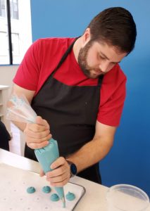 Alex at Macaron Bar piping out batter for macarons