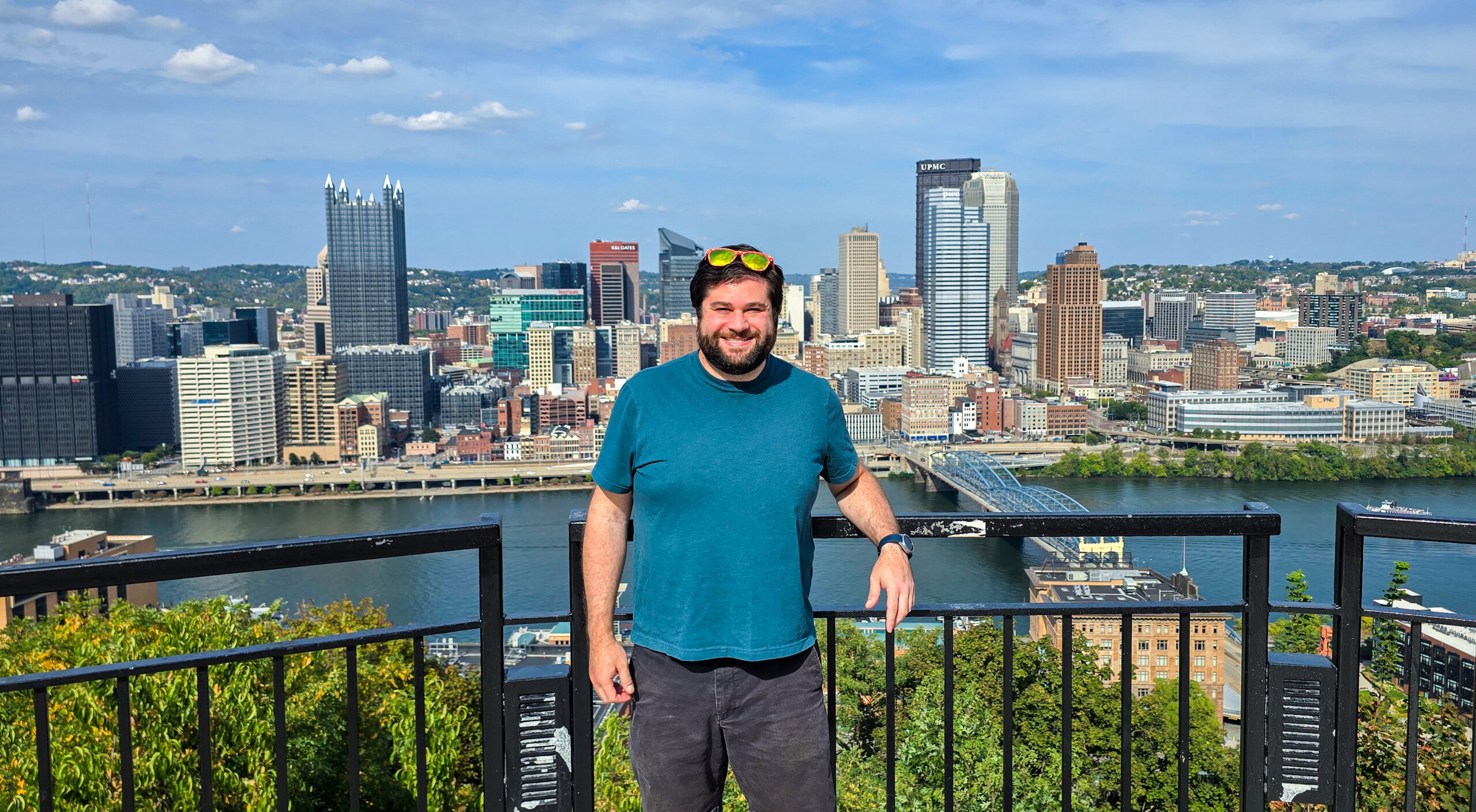 Alex standing at the Mon Incline Overlook in Mt Washington Pittsburgh with the Pittsburgh skyline in the background