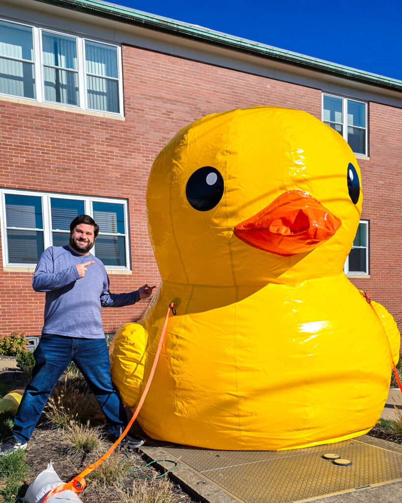 Alex standing next to a giant inflatable rubber duck