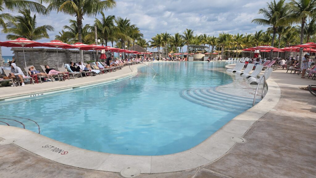 pool with beach umbrellas and pool lounge chairs at the Virgin Voyages Bimini Beach Club in the Bahamas